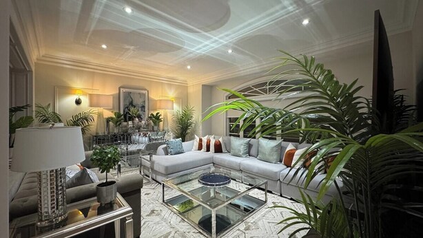 A modern living room with a sectional sofa, a glass coffee table, and various plants. - Richmond Hill Mansion | Ultimate Executive Retreat (Richmond Hill)