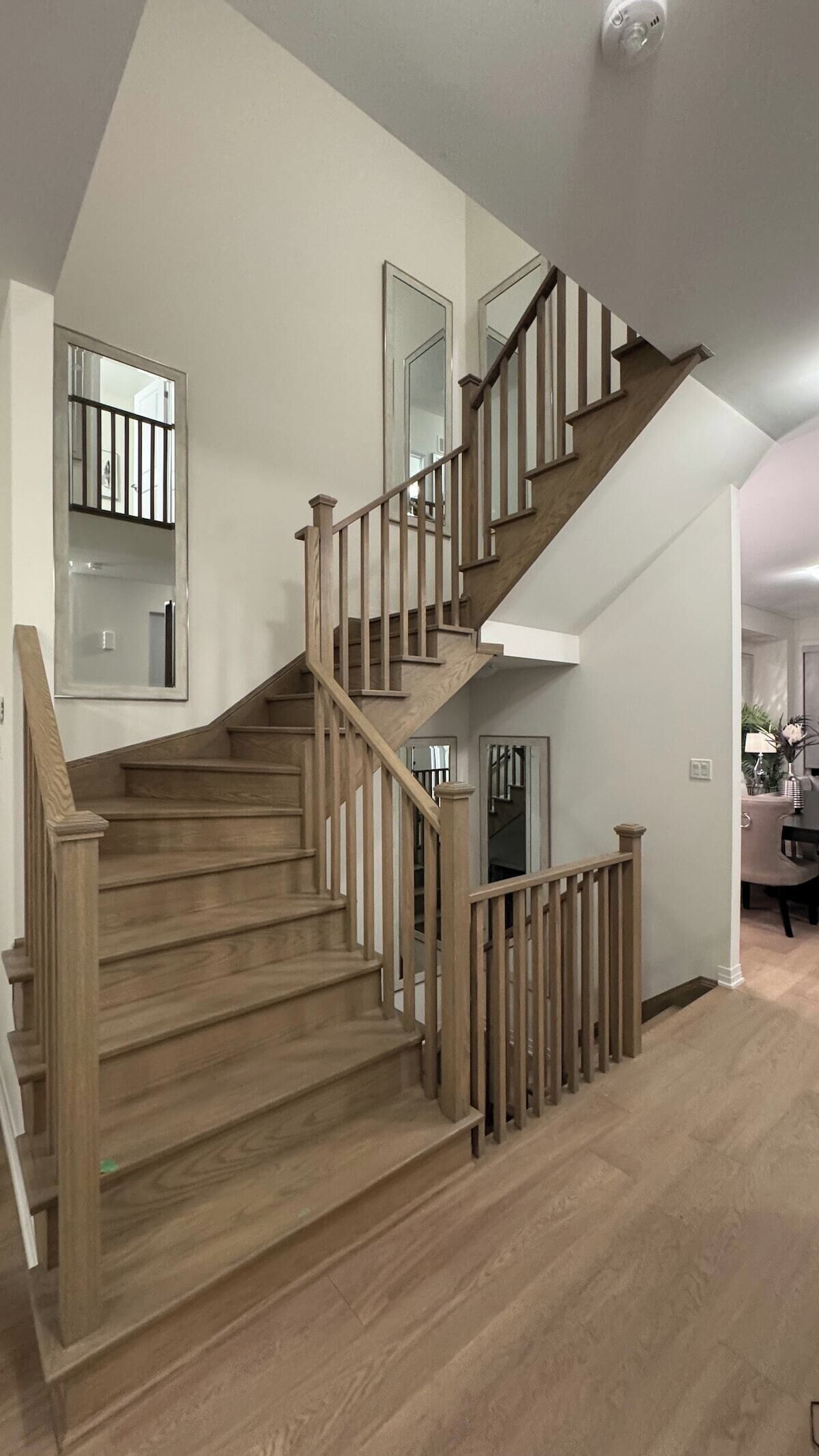 Un escalier en bois, doté d’une rampe, menant à l’étage supérieur.
