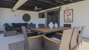An outdoor patio with a dining table, wicker chairs, a sofa, and a ceiling fan. - Great 4BR Pool Home – Perfect for Families & Group Getaways (Phoenix)