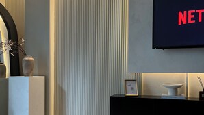A modern living room with a flat-screen TV, a chessboard, and a minimalist design. - Liverpool City Centre Luxury 2 Bedroom 2 Bathroom Balcony Flat - Cheap Parking (Liverpool)