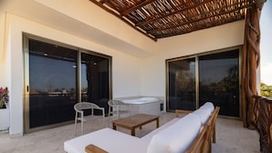A covered outdoor seating area with a sofa, chairs, and a table. - Hotel Kaan Holbox (Isla Holbox)