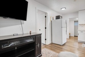 A modern kitchen with a refrigerator, a microwave, and a flat-screen TV mounted on the wall. - Private Boise Bench Retreat (Boise)