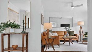 A living room with a sofa, coffee table, and a TV. - Modern 10th St Retreat: Downtown & Hyde Park (Boise)
