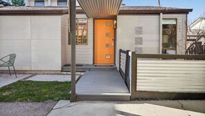 A building with a flat roof, a wooden deck, and a metal gate. - 24th St Hideaway - Pet Friendly North End Retreat (Boise)