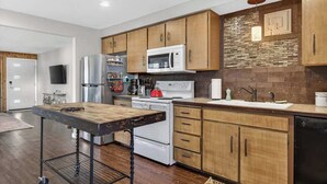 A modern kitchen with wooden cabinets, stainless steel appliances, and a central island. - 24th St Hideaway - Pet Friendly North End Retreat (Boise)
