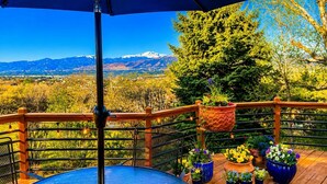 A deck with a view of mountains, a blue umbrella, and potted plants. - Ultimate AFA Graduation Estate: 5 Private Acres - 5 Mins to North Gate (Colorado Springs)
