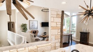 A modern kitchen with a stone accent wall, a wooden ceiling, and a large window. - Ultimate AFA Graduation Estate: 5 Private Acres - 5 Mins to North Gate (Colorado Springs)