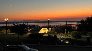 Ein Sonnenuntergang mit Park, Brücke und einer entfernten Bergkette.