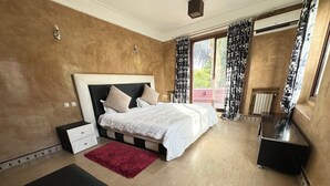 Ein Schlafzimmer mit einem Bett, Nachttischen, einem roten Teppich und einem Fenster mit Vorhängen.