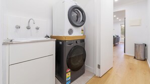 Un lavadero con lavadora, secadora y lavabo.