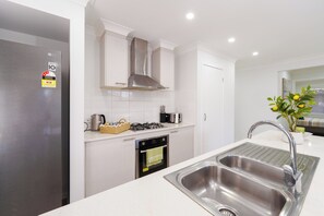 Una cocina moderna con un refrigerador de acero inoxidable, una estufa a gas y un lavaplatos doble.