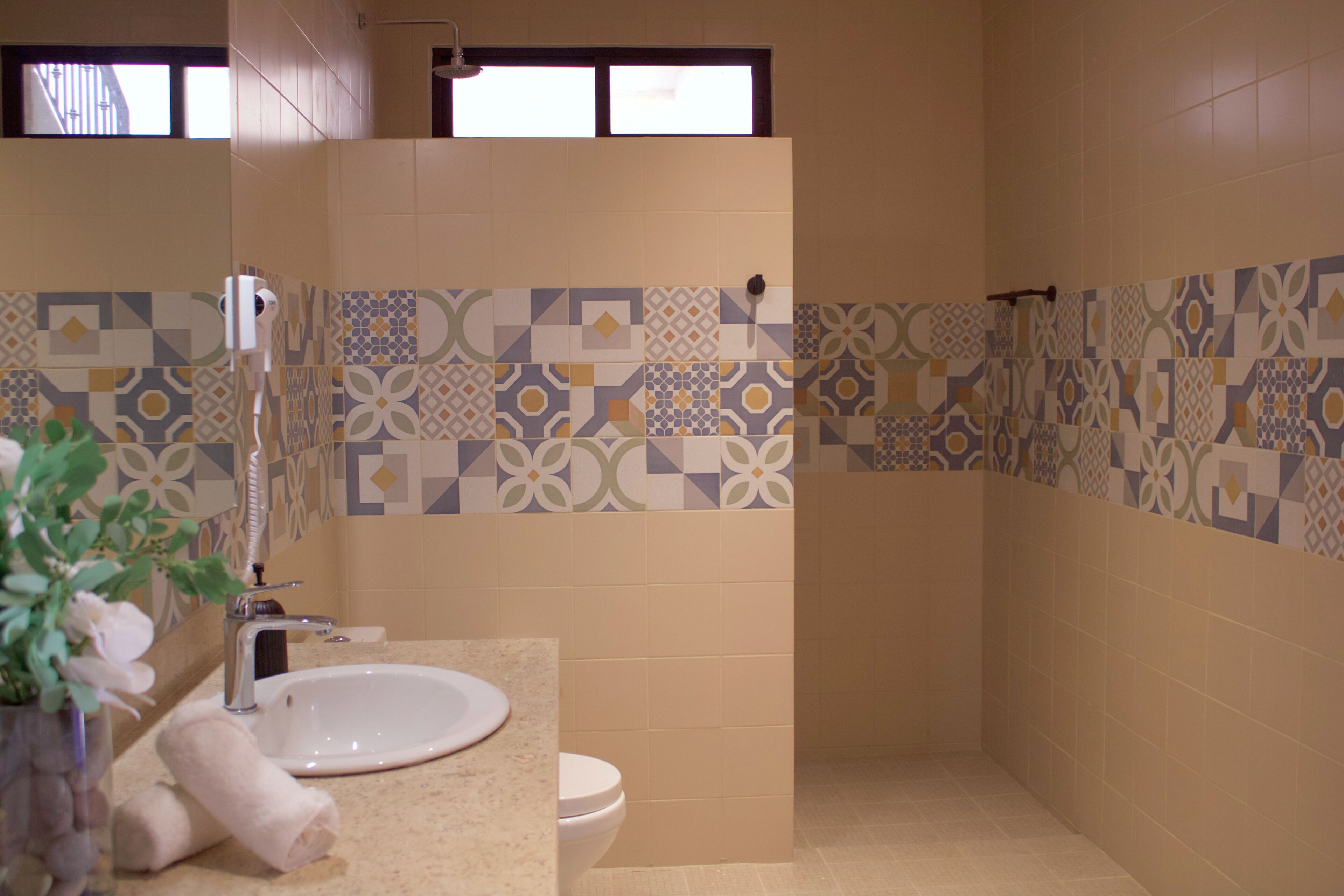 A bathroom with a sink, toilet, and shower area.