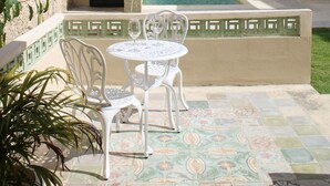 A courtyard with a pool, white outdoor furniture, and a stone building. - Casa Ku'x (Merida)