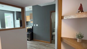 Una cocina moderna con armarios de madera, un refrigerador de acero inoxidable y una ventana con persianas.