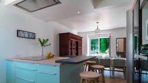Una cocina moderna con una isla grande, taburetes de bar y un comedor con vistas.