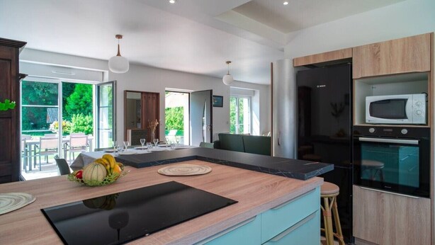 Una cocina moderna con encimera de madera, electrodomésticos integrados y un comedor con vistas.