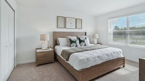 A bedroom with a wooden bed, bedside lamps, a nightstand, a window with blinds, and a door. - Kissimmee Retreat 4BR House for 8 (Kissimmee)