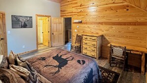 A log cabin bedroom with a bed, dresser, and a ceiling fan. - Secluded Cabin + Private Lake Access - No Parkway Traffic - Hidden Ridge Retreat (Sevierville)