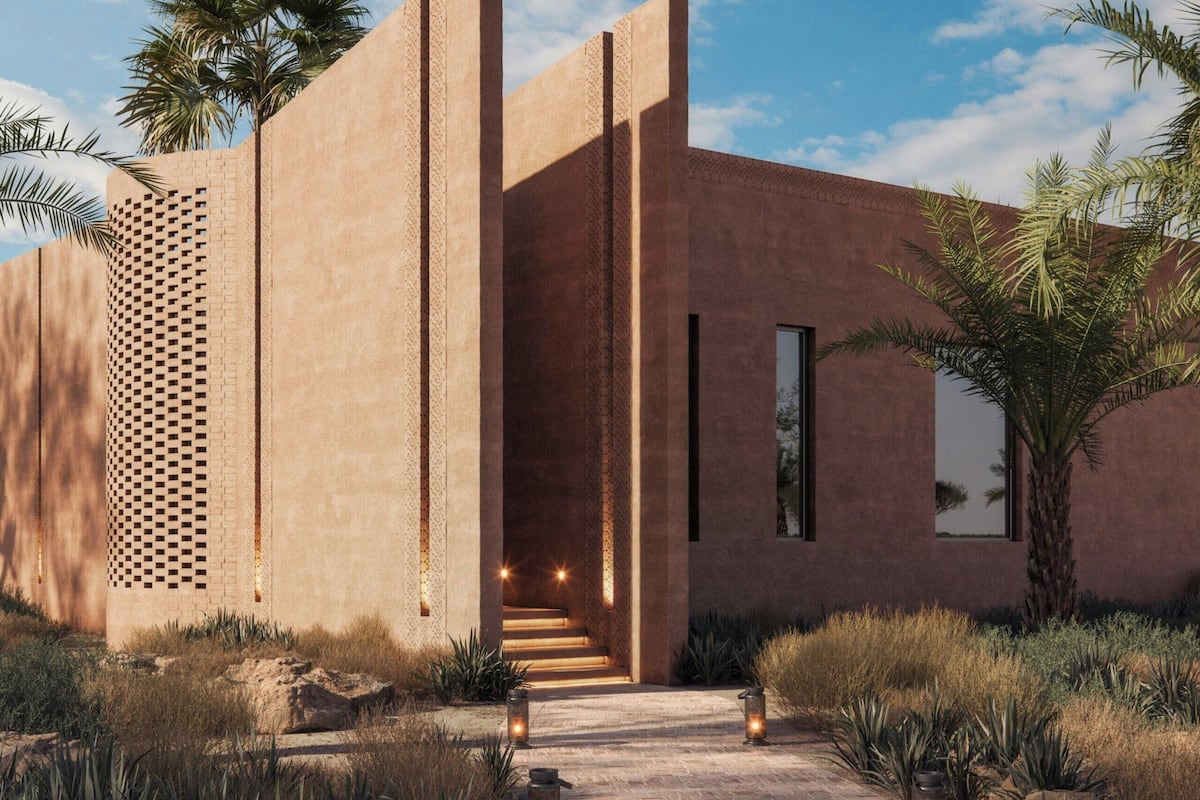 A modern building with a brick facade, a central entrance, and a pathway leading to it.
