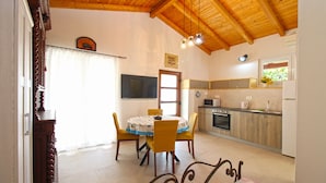 A dining area with a table and chairs, a kitchen with appliances, and a wooden ceiling. - Studio apartment 1707/204214 (Istria - Banjole), 100m from the beach (Banjole)