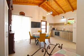 A dining area with a table and chairs, a kitchen with appliances, and a wooden ceiling. - Studio apartment 1707/204214 (Istria - Banjole), 100m from the beach (Banjole)