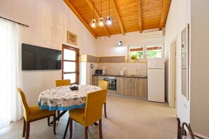 A compact kitchen with a dining area, wooden ceiling, and a flat-screen TV mounted on the wall. - Studio apartment 1707/204214 (Istria - Banjole), 100m from the beach (Banjole)