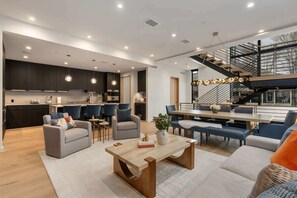 A modern living space with a kitchen, dining area, and staircase. - Abode at Sky View, rooftop hot tub, walk to town (Jackson)
