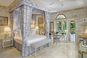 Ein Schlafzimmer mit einem Himmelbett, einem Schreibtisch und einer Bank.