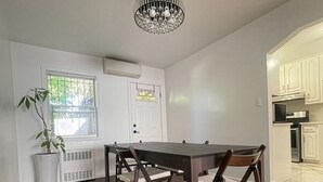 Un comedor con mesa y sillas, una planta en maceta y un candelabro.
