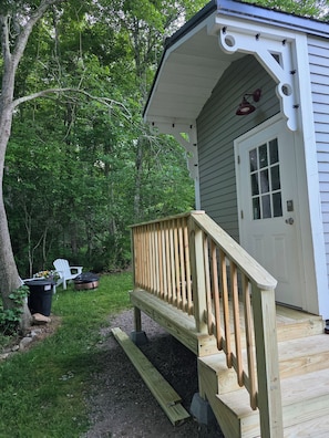 A wooden deck leading to a white building with a door and windows. - Rare Find: Unique Stonington Tiny House on Private Horse Farm & Kennel (Stonington)