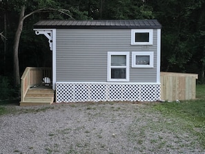 A small, single-story building with a porch, a wooden deck, and a fenced area. - Rare Find: Unique Stonington Tiny House on Private Horse Farm & Kennel (Stonington)