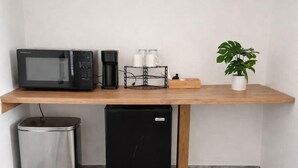 A kitchenette with a microwave, coffee maker, and a small refrigerator. - Sunny Poolside Retreat | Near Beach & Dining (Clearwater)