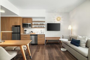 Una cocina moderna con armarios de madera, un microondas integrado y un lavavajillas.