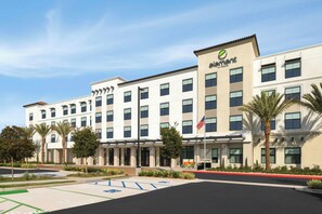 A hotel with a modern facade, multiple windows, and a parking lot with designated spaces. - Element by Marriott San Diego Chula Vista (Chula Vista)