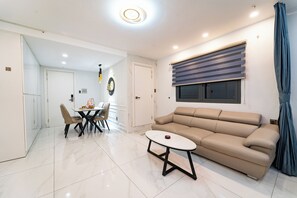 Un salon moderne comprenant un canapé, une table à manger avec des chaises et une petite table basse.