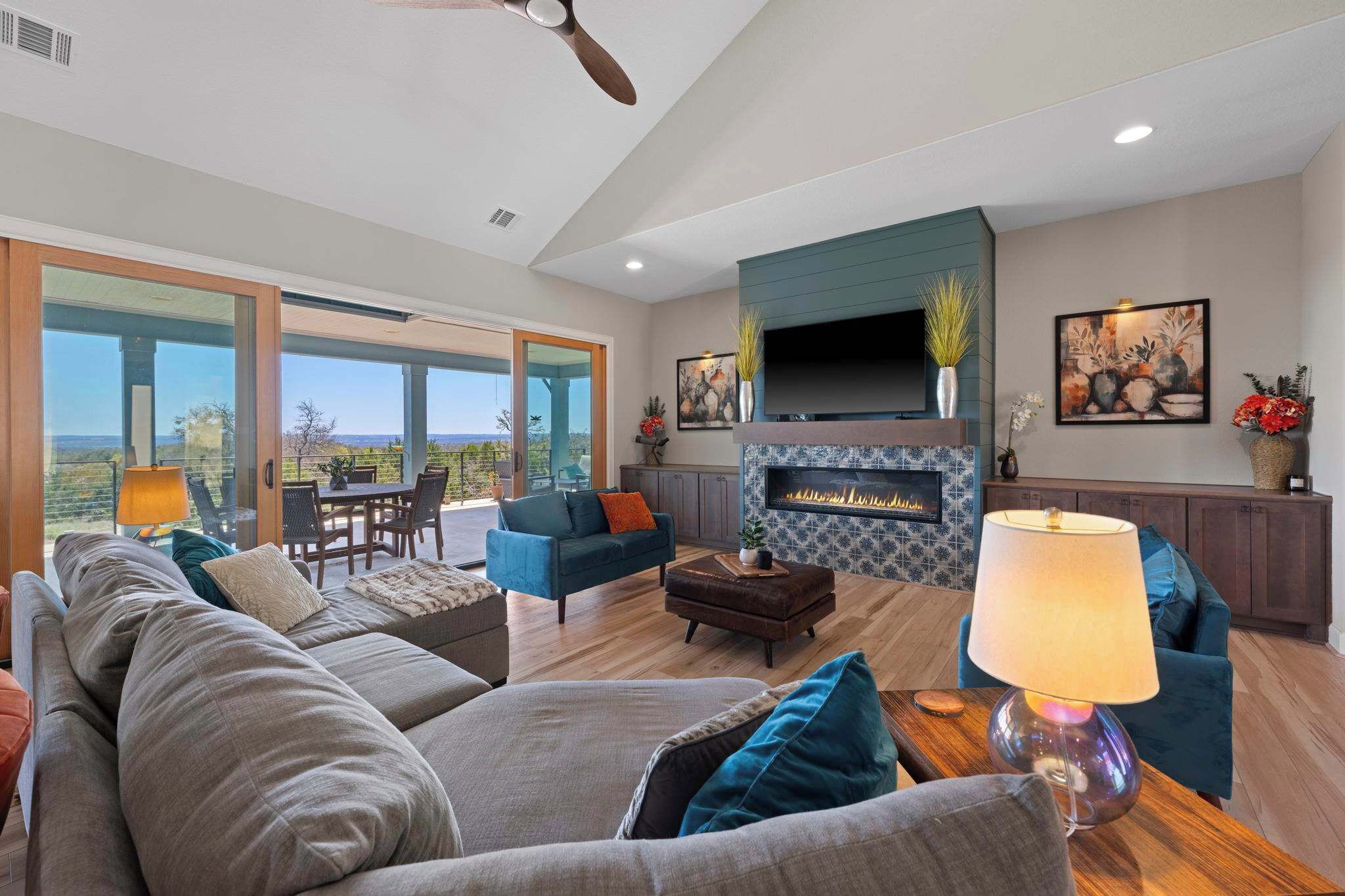 A spacious living room with a fireplace, comfortable seating, and a large window overlooking a scenic view.
