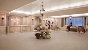 A spacious hotel lobby with a central round table, seating area, and decorative elements. - Emerald Suite 607 ~ Luxury 3BR Oceanfront + Full Resort Amenities Included (Galveston)