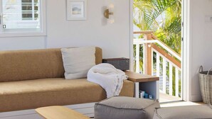 Ein modernes Wohnzimmer mit einer Couch, einem Hocker und einem Holztisch.