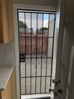 A door with a metal security screen, a keyhole, and a door handle. - 1 month minimum - private studio unit in North Long Beach neighborhood (Long Beach)