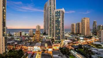 A cityscape with high-rise buildings, a waterfront, and a well-lit urban area.