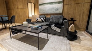 Un salon moderne avec un canapé, une table basse et un tableau accroché au mur.
