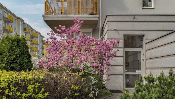Ein Gebäude mit Balkon, einer Tür und einem kleinen Fenster.