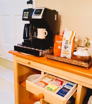 A coffee machine, a mug, a coffee bag, and a tray with coffee cups on a wooden table. - This Old House / Cozy 3 BR near Sayers Lake (Howard)
