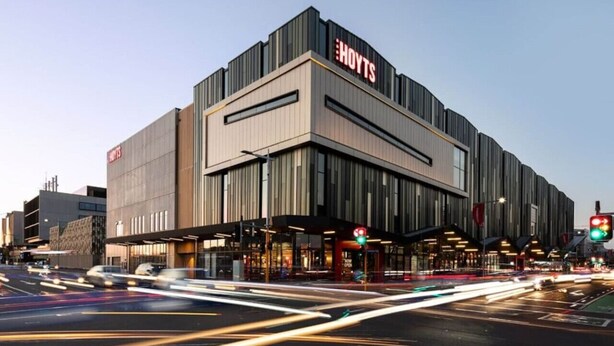 Een modern hotel met een opvallend 'HOTELS' bord, met een eigentijds architectuurontwerp, een plat dak en grote ramen.
