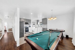 A modern kitchen with a pool table, a dining area, and a laundry room. - Stylish 3BR Home • Game Room • Free Parking • Sleeps 16 (White Plains)
