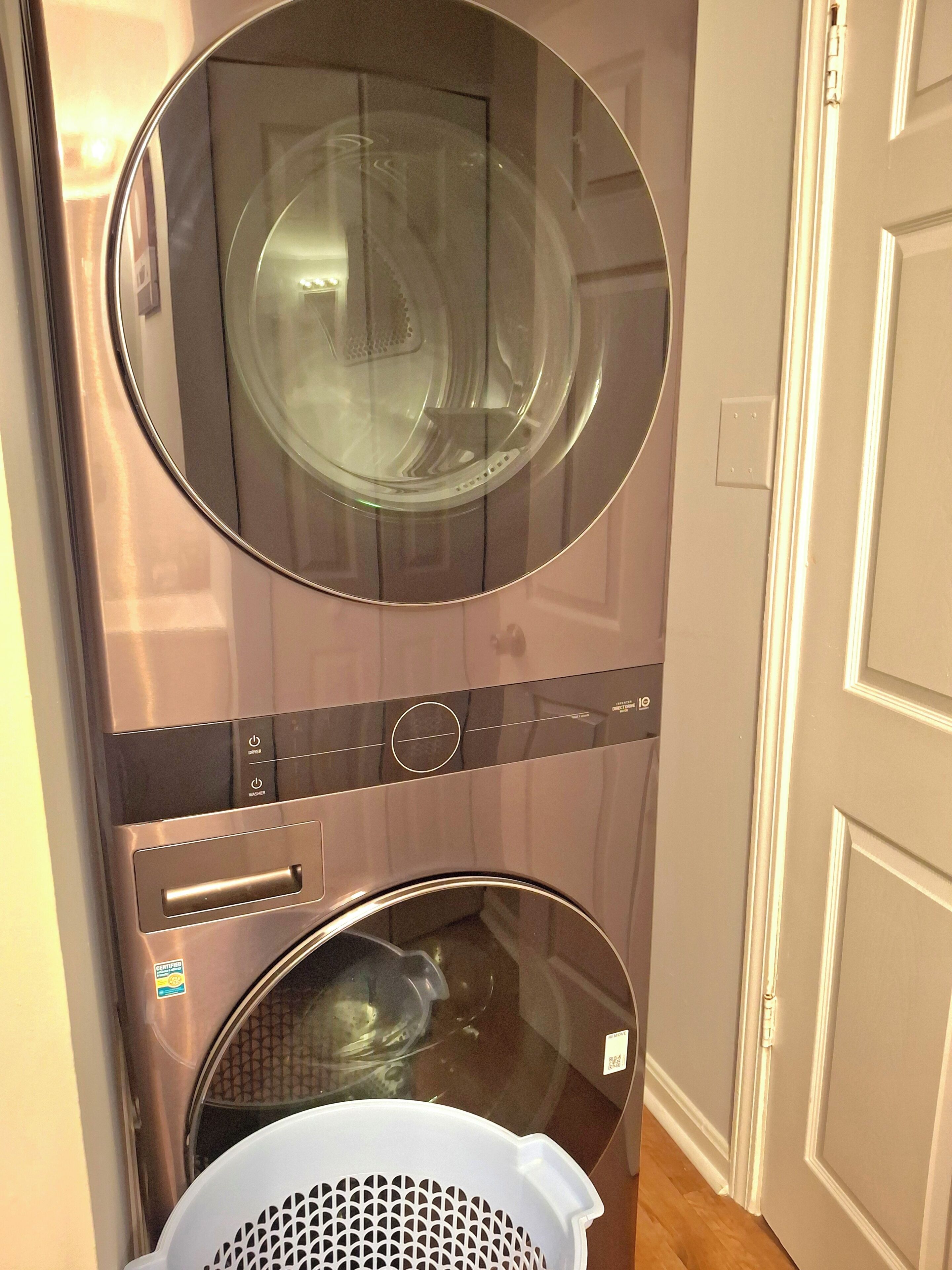 Une machine à laver compacte, fixée au mur, dotée d’un panneau de commande et d’un sèche-linge situé en dessous.