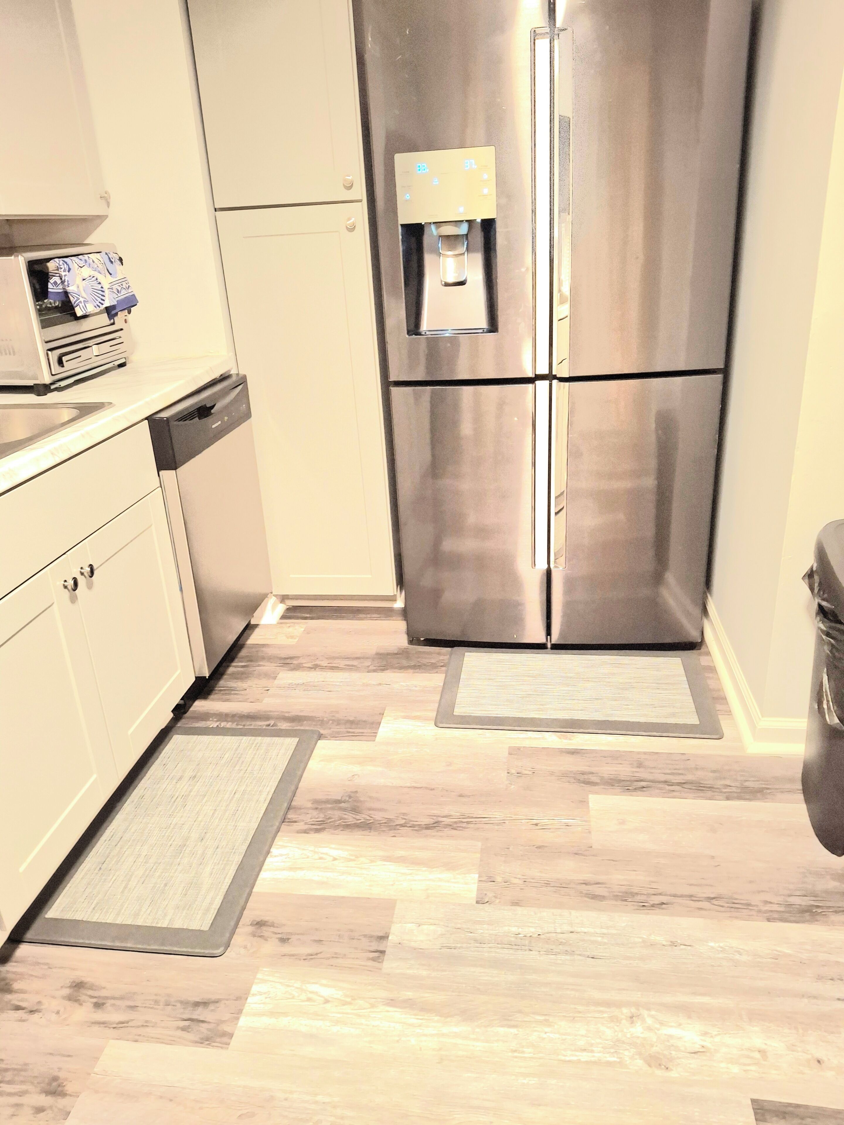 Una cocina con un refrigerador de acero inoxidable, lavavajillas y dispensador de agua.