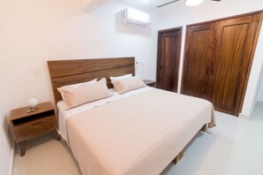 A bedroom with a bed, nightstand, and wooden wardrobe. - CASITA VERSALES PRIME LOCATION IN PUERTO VALLARTA (Puerto Vallarta)