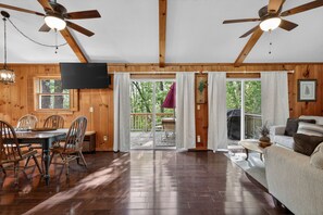 A wooden interior with a dining area, a sofa, and a TV. - Moneta Memories Lake Retreat | Hot Tub & Fire Pit (Moneta)