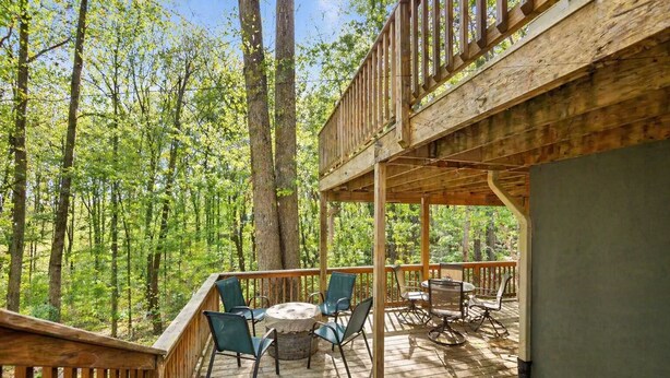 A wooden deck with outdoor seating and a view of a forest. - Moneta Memories Lake Retreat | Hot Tub & Fire Pit (Moneta)